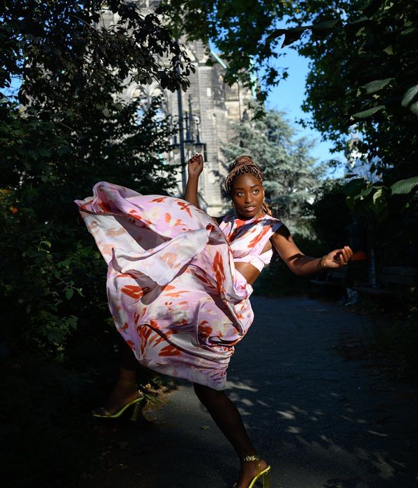 Woman performing a gentle, energetic movement in a bright room.